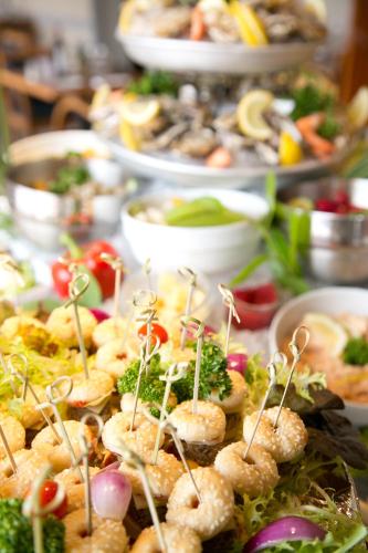 a table filled with plates of food with appetizers at Kyriad Prestige - Bordeaux Aeroport in Mérignac