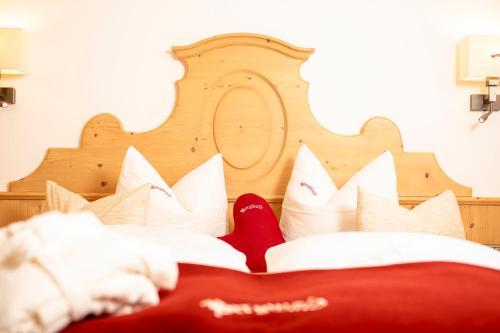 a person reading a book on a bed with pillows at Bergwald Appartements Alpbach in Alpbach