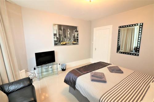 a bedroom with a bed and a flat screen tv at Marley Mansion Apartments - Borough in Birkenhead