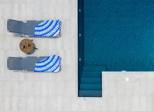 an overhead view of three swimming pools and a clock at Casa Bianca Villa in Kolymbia