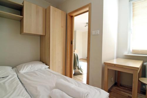 a bedroom with a bed and a desk and a window at Apartament Skwer Gdynia in Gdynia