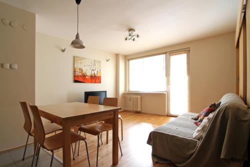 a living room with a dining room table and a table and chairs at Apartament Skwer Gdynia in Gdynia