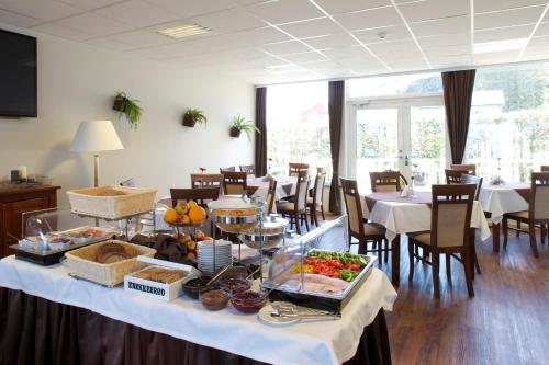 a buffet table with food on it in a restaurant at Kinn Hotell Florø in Florø