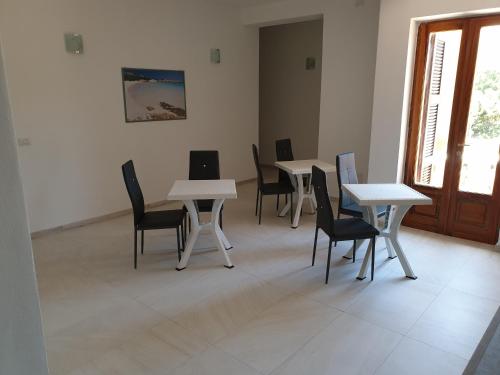 a group of tables and chairs in a room at Guest House Tra Rocce E Mare in La Maddalena