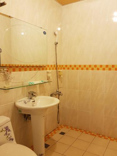 a bathroom with a sink and a toilet and a mirror at Jhen Pin Xuan B&B in Taitung City