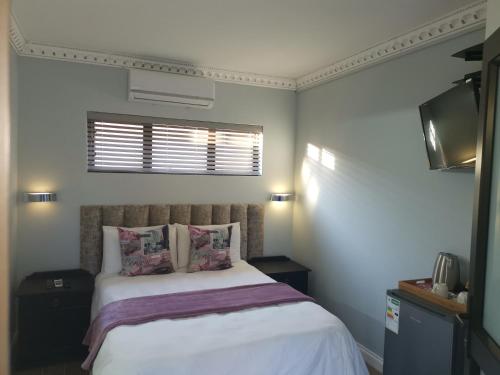 a bedroom with a bed and a window at Lucolo Palace B&B - Mthatha in Mthatha