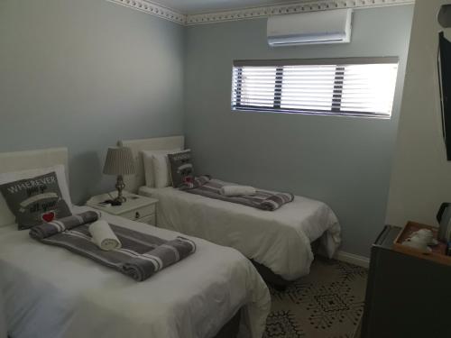 a bedroom with two beds and a window and a window at Lucolo Palace B&B - Mthatha in Mthatha