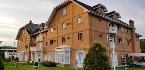 un gran edificio de ladrillo marrón con ventanas blancas en Grand Ville Hotel, en São Lourenço