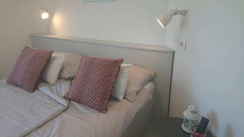 a white bed with two pillows on top of it at Apartments Nina in Rab