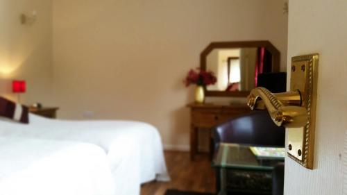 a room with a bed and a door with a mirror at Miltons Country Lodge in Langford