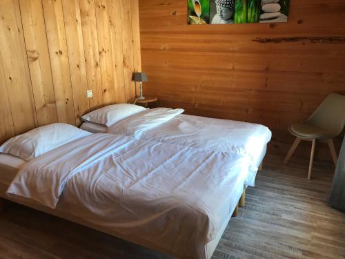 a bedroom with two beds and a chair in it at La Ferme des Georgières "Séjour en tout compris" in Notre-Dame-de-Bellecombe