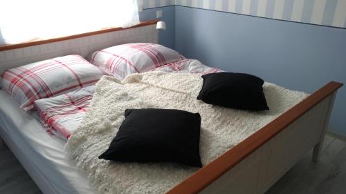 a bed with two pillows on it in a bedroom at Ferienwohnungen direkt am See in Mücheln