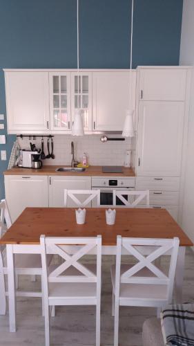 a kitchen with a wooden table and white cabinets at Ferienwohnungen direkt am See in Mücheln