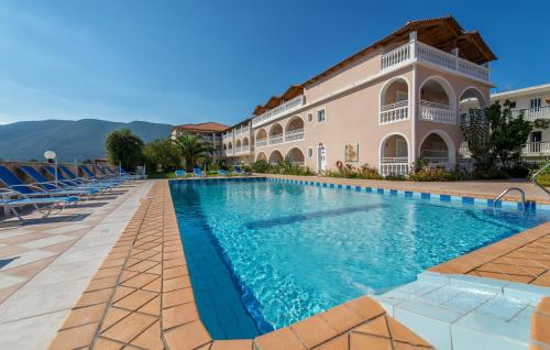 a swimming pool in front of a building at Dennis Studios in Alikanas