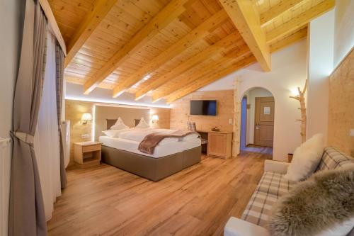 Habitación de hotel con cama y sofá en Hotel Ciamp en Santa Cristina in Val Gardena