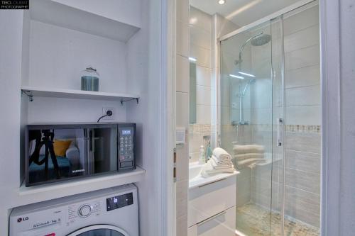 een badkamer met een wasmachine en een douche bij T2 PRESTIGE BANDOL in Bandol