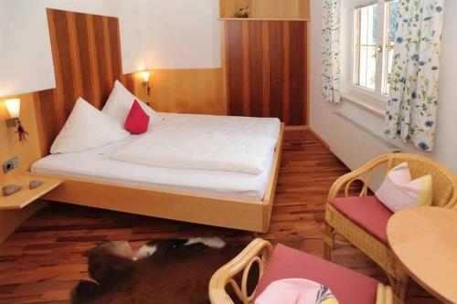 a bedroom with a bed and a cat laying on the floor at Haus Ender in Sankt Gallenkirch