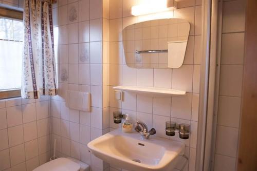 y baño con lavabo, espejo y aseo. en Haus Ritzenspitze, en Gargellen