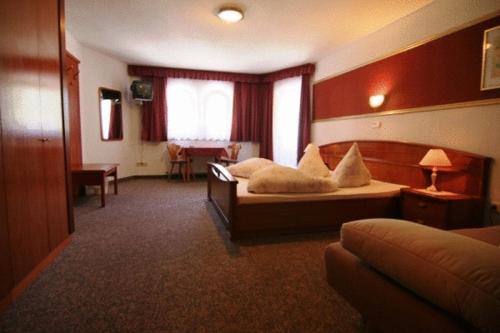 een hotelkamer met een bed, een bureau en een slaapkamer bij Hotel Lenzenhof in Oberau