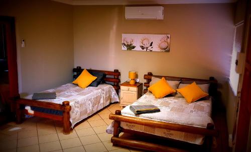 um quarto com 2 camas e almofadas amarelas em LE -DANTE em Klerksdorp