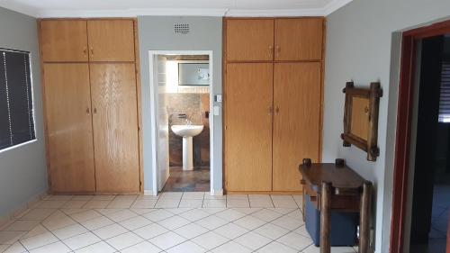 a bathroom with wooden cabinets and a sink at LE -DANTE in Klerksdorp