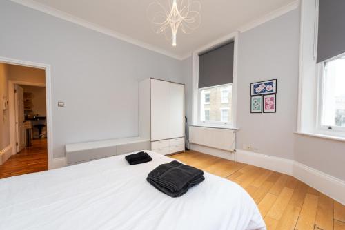 ロンドンにあるCamden Apartment A/Apartmentの白いベッドルーム(大きな白いベッド1台、窓2つ付)