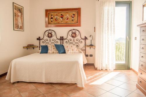 1 dormitorio con 1 cama blanca grande con almohadas azules en Villa Aurora, en Olbia