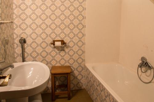 a bathroom with a sink and a tub and a toilet at Albergue La Cabaña in Turieno