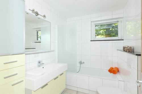 uma casa de banho branca com um lavatório e um espelho em Ferienhaus Grappa em Bartholomäberg