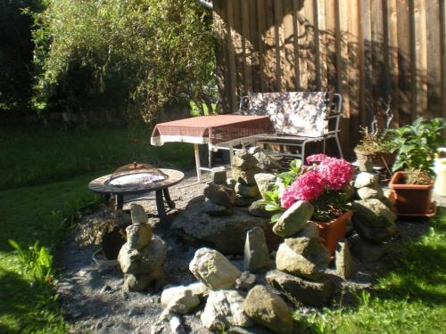 a garden with a table and a bench and flowers at Haus Gant in Sankt Gallenkirch