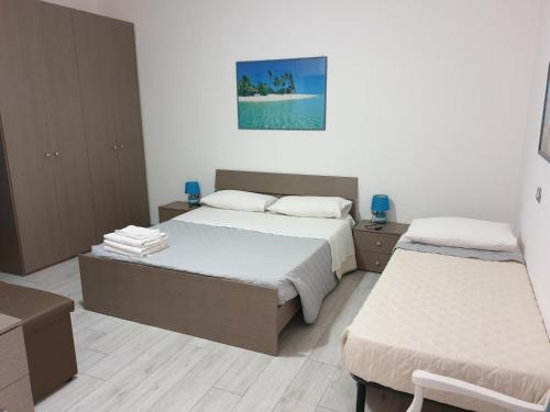ein Schlafzimmer mit 2 Betten und einem Wandgemälde in der Unterkunft Guest House Tra Rocce E Mare in La Maddalena
