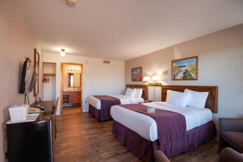 a hotel room with two beds and a television at Dutch Inn in Cornwall