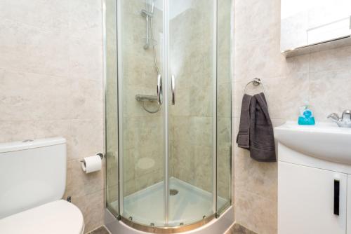 a bathroom with a shower and a toilet and a sink at Camden Apartment E/Apartment in London