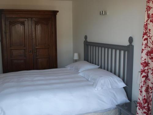 - une chambre avec un lit doté de draps blancs et d'une porte en bois dans l'établissement Appartement Mozart, à Strasbourg