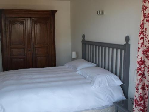 a bedroom with a bed with white sheets and a wooden door at Appartement Mozart in Strasbourg
