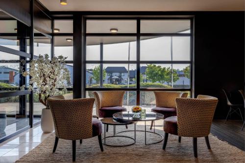a lobby with a table and chairs and windows at Hotel Ter Elst in Edegem