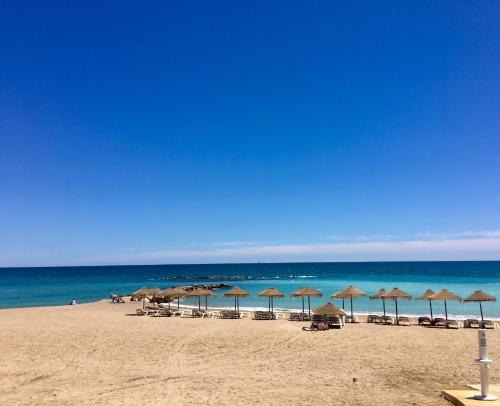 a beach with umbrellas and chairs and the ocean at ViNALUX in Vinaròs