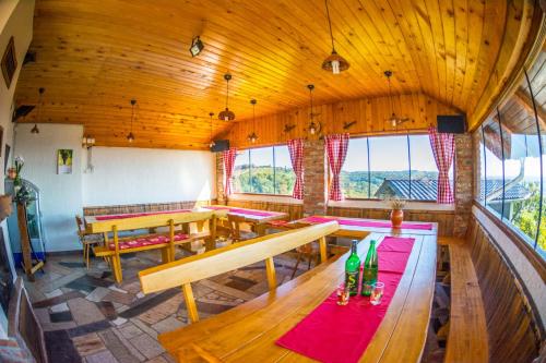 a large room with wooden tables and benches and windows at Vinska klet Smej in Lendava