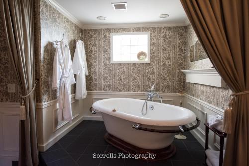 a bathroom with a bath tub and a window at Inn on Broadway in Rochester
