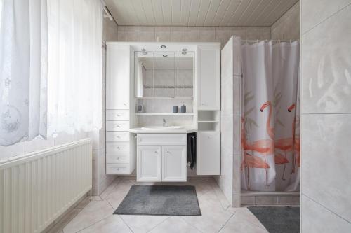 a white bathroom with a sink and a shower at Ferienwohnung AOLI in Gmunden