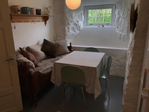 Cette chambre comprend une table, un canapé et une fenêtre. dans l'établissement Arctic Garden, à Lødingen