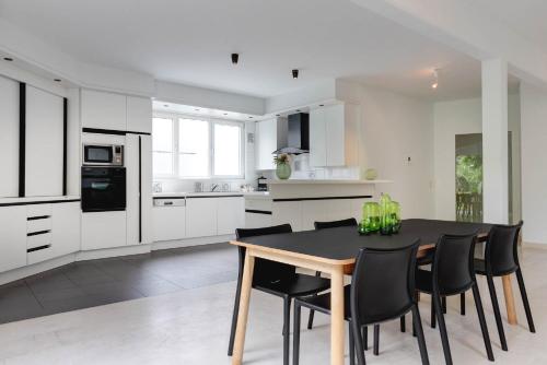 a kitchen with a black table and black chairs at Hotel Ter Elst in Edegem