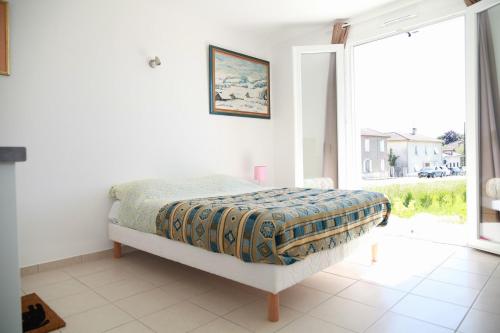 une chambre avec un lit et une grande fenêtre dans l'établissement Villa Marcus, à Castelnau-Magnoac