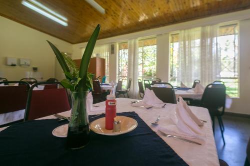 uma mesa com um vaso com uma flor em Corat Africa Hotel em Nairobi