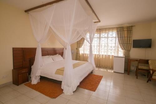 a bedroom with a bed with a canopy at Corat Africa Hotel in Nairobi
