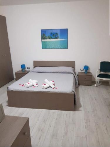 a bedroom with a bed with two towels on it at Guest House Tra Rocce E Mare in La Maddalena