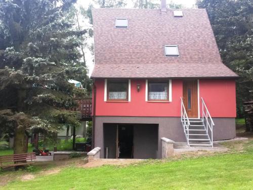 une maison rouge avec un toit rouge et un escalier dans l'établissement Holiday home in Erzgebirge Mountains with terrace, à Mezihoří