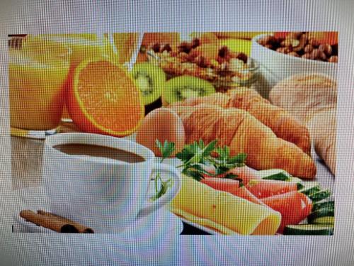 a cup of coffee next to a plate of fruit at Hotel Germania in Cologne