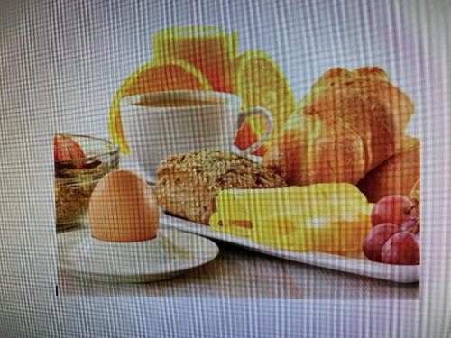 einen Teller mit Brot und eine Tasse Kaffee in der Unterkunft Hotel Germania in Köln