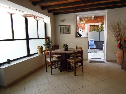 a dining room with a table and chairs and windows at Corte Navari - Loft Principe Filippo in Pietrasanta